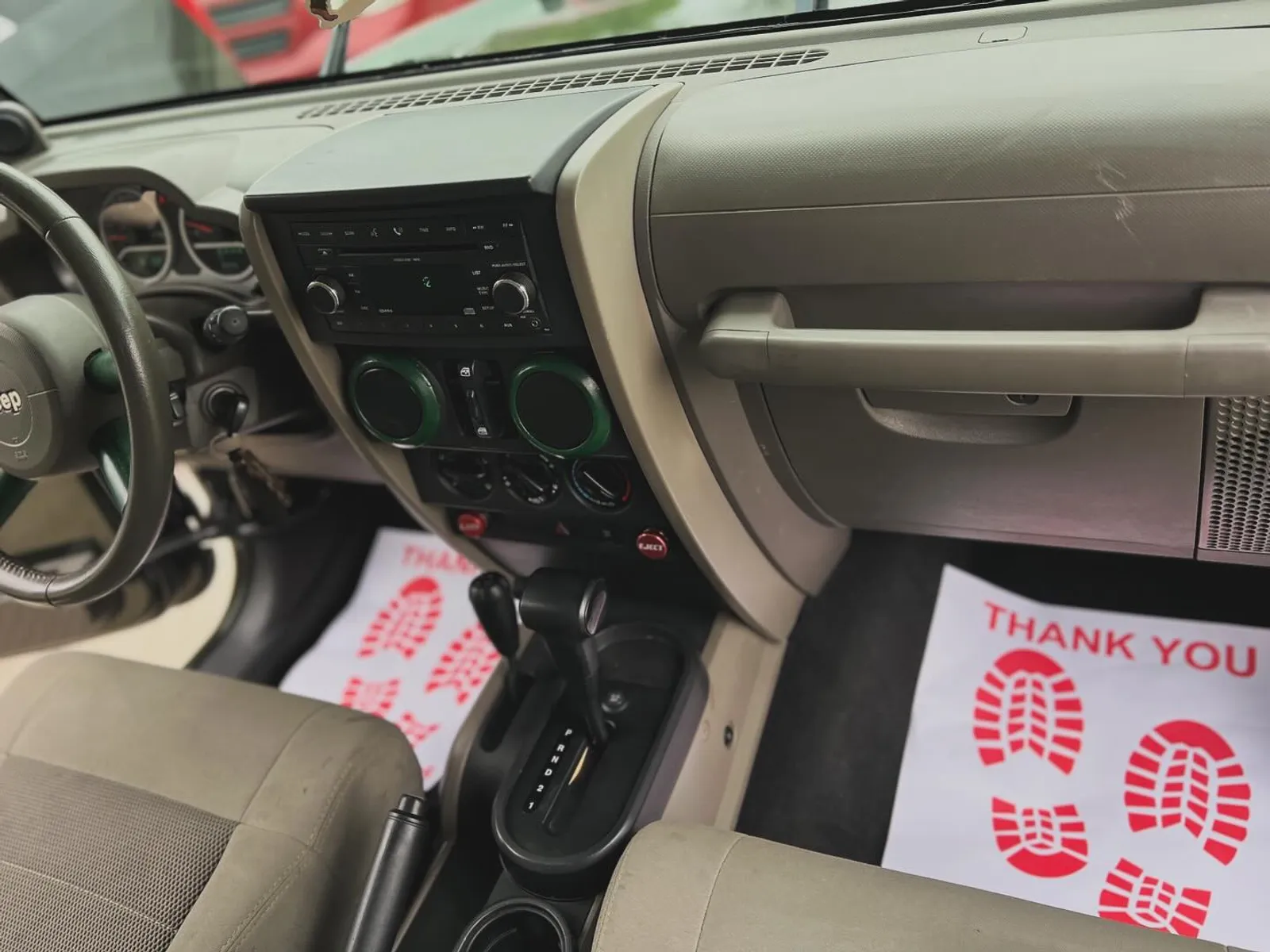 After — the same Jeep Wrangler front cabin cleaned and detailed, floor mats down