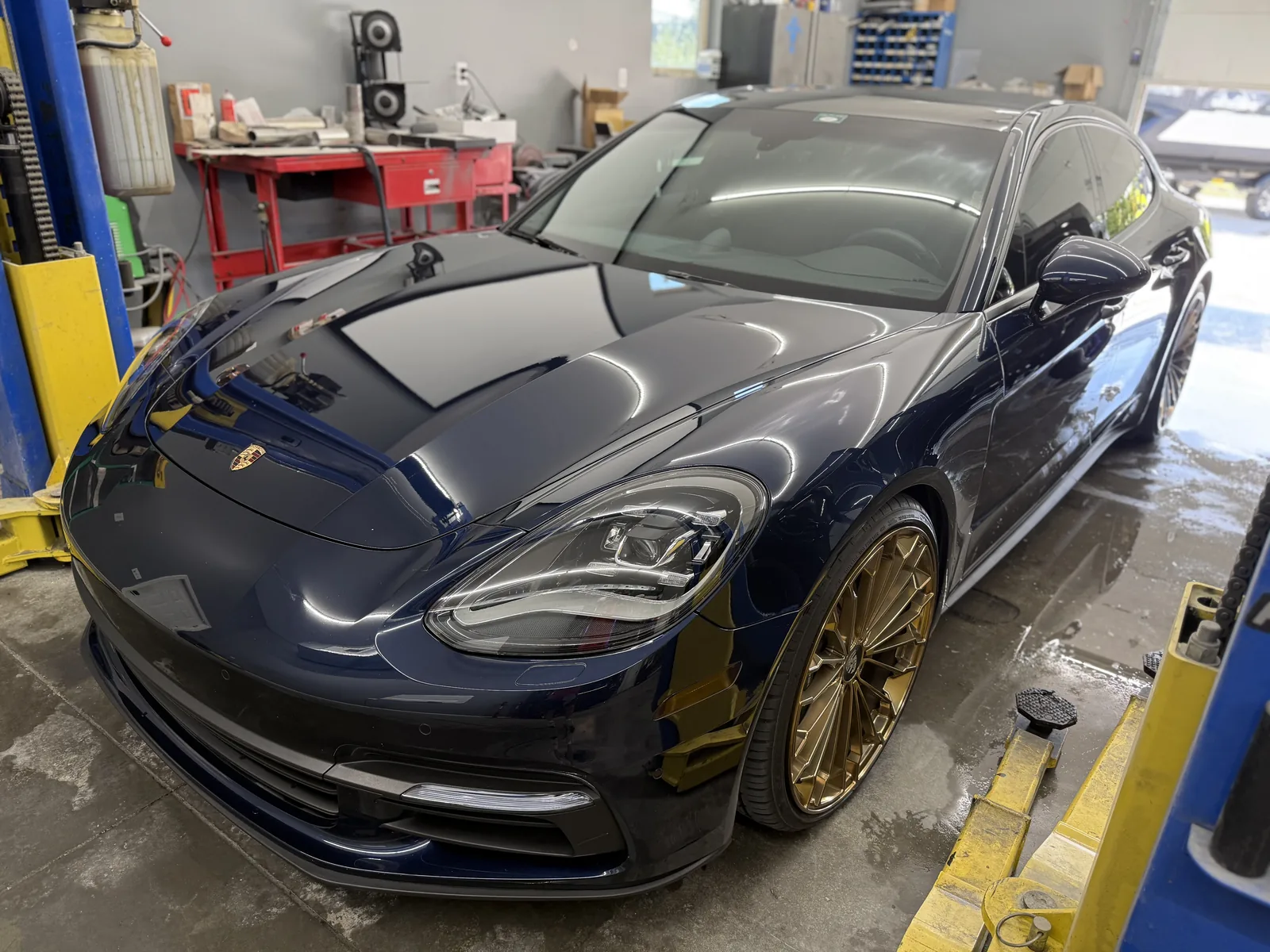 A navy-blue Porsche Panamera with deep, mirror-gloss paint after correction by Wax N' Go