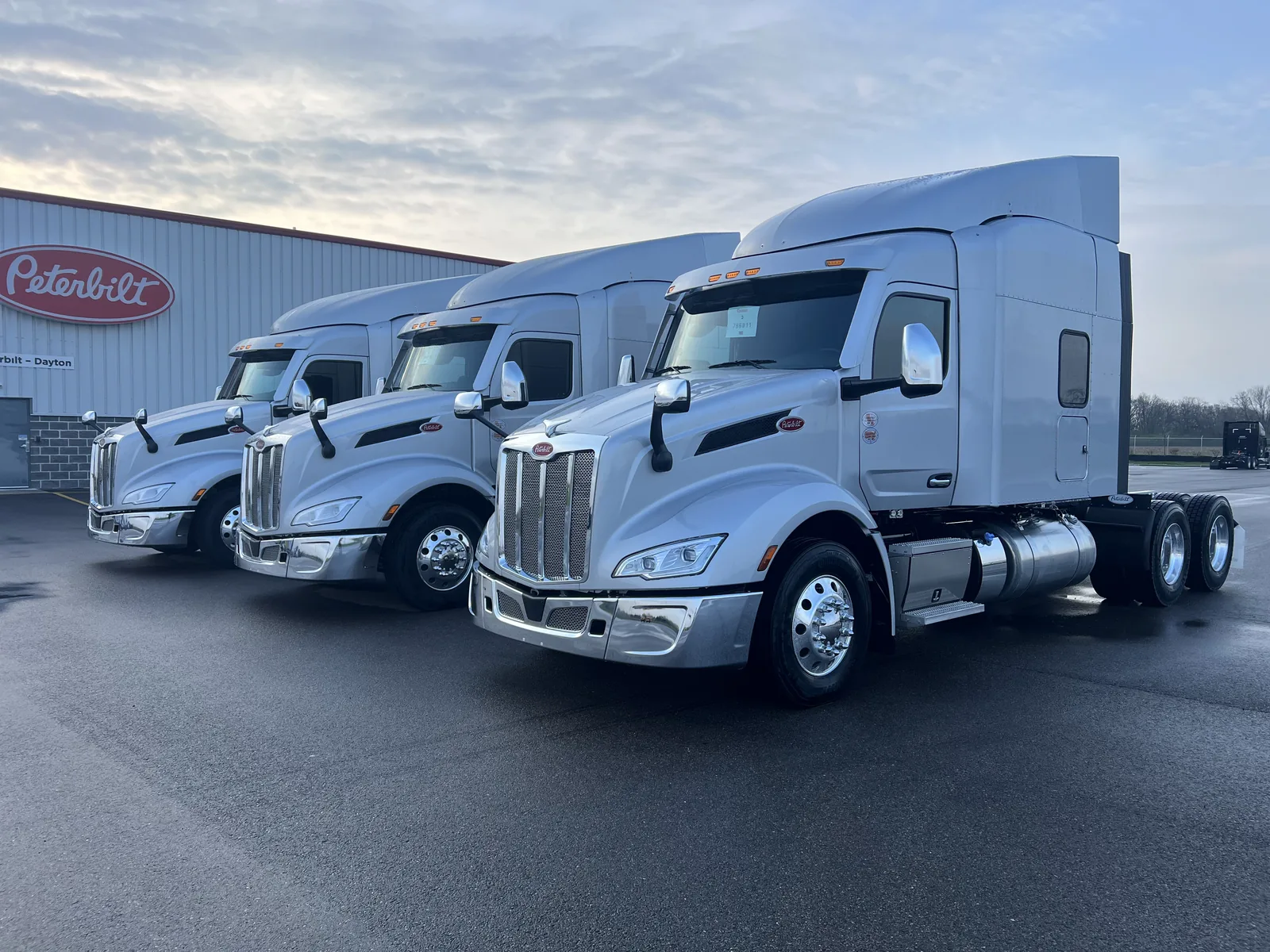 Three Peterbilt semi trucks lined up and detailed by Wax N' Go at the Peterbilt of Dayton lot