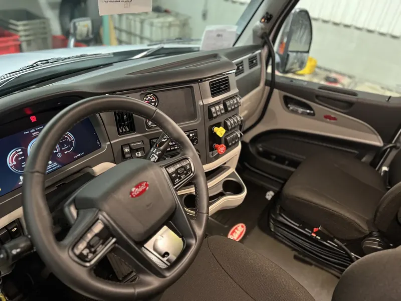 Peterbilt semi cab cockpit after interior detailing — dash, steering wheel, and trim cleaned